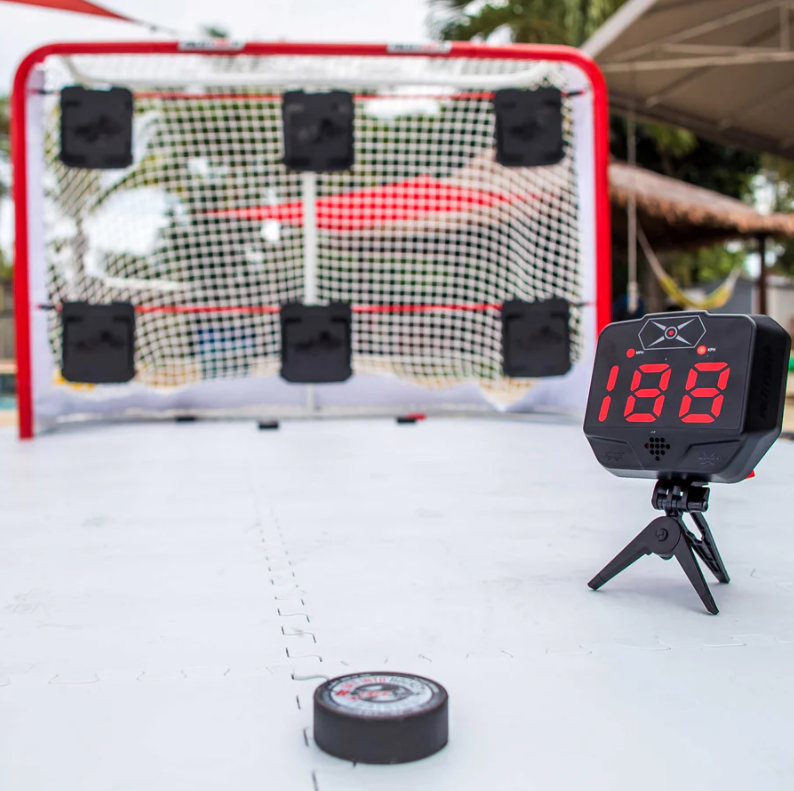 A photo of the HockeyShot Extreme Hockey Radar 2.0 in colour black with red numbers. Action view.