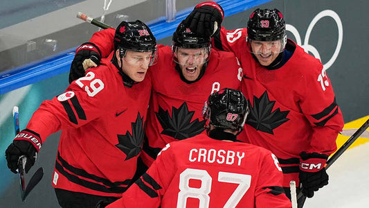 A photo of the 2026 team Canada with Connor McDavid, Nathan MacKinnon, and Sydney Crosby celebrating a goal.