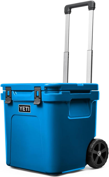 A photo of the Yeti Roadie 48 Wheeled Cooler in colour big wave blue, front, closed-lid view.