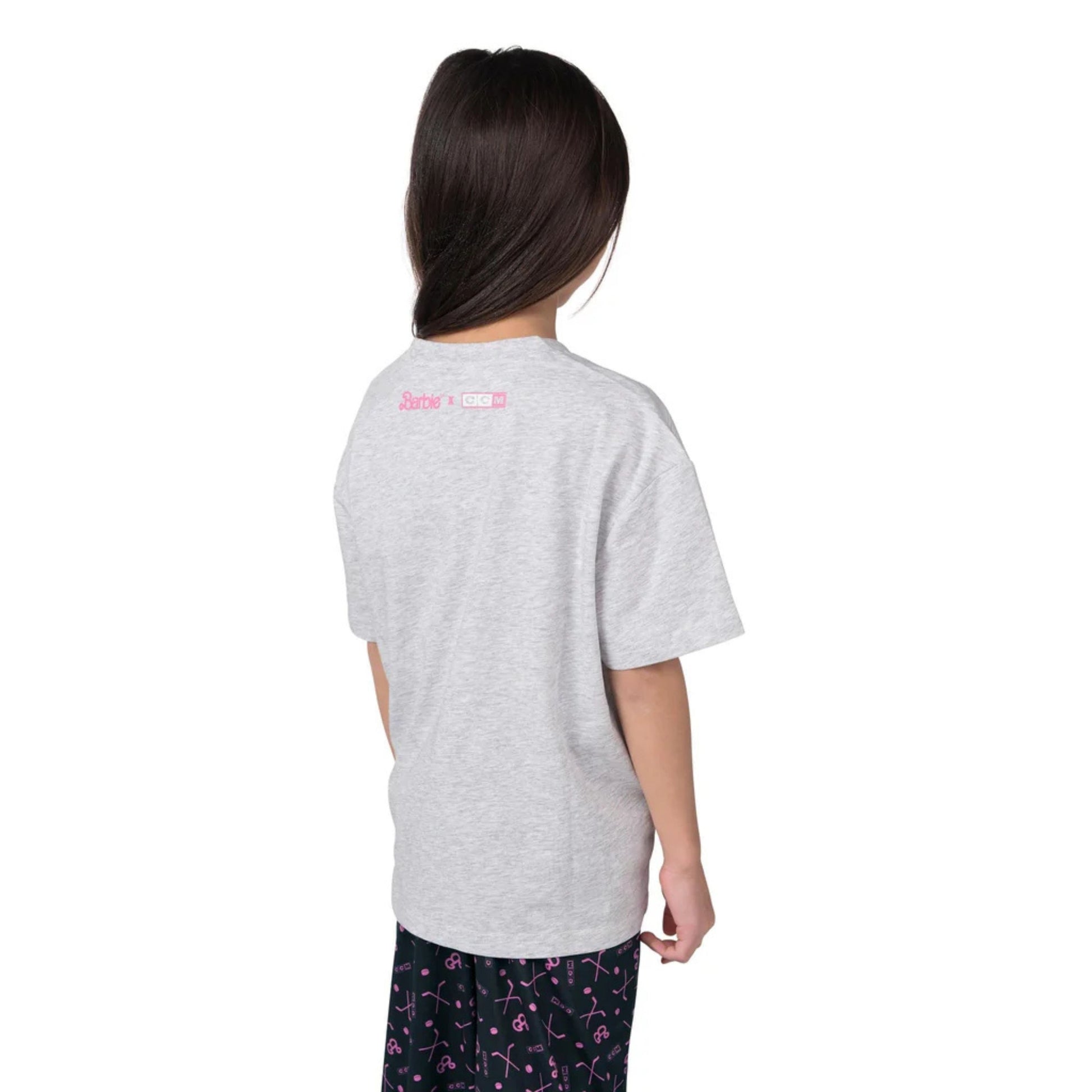A photo of a child wearing a grey Barbie™ x CCM Grey Goal Getter Short Sleeve T‑Shirt