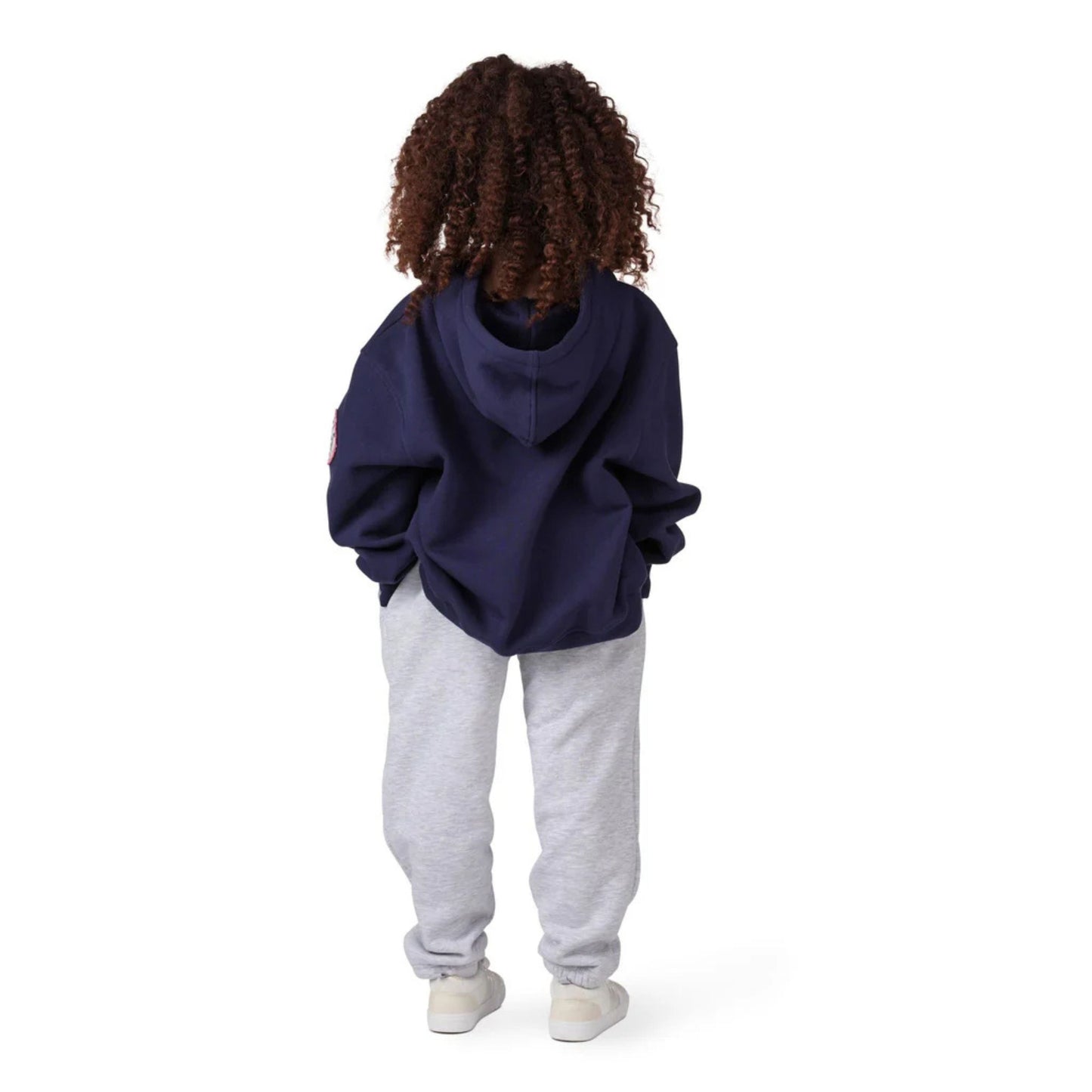A photo of a child wearing grey sweat pants and Barbie x CCM Navy Pullover Youth Hoodie in colour navy.