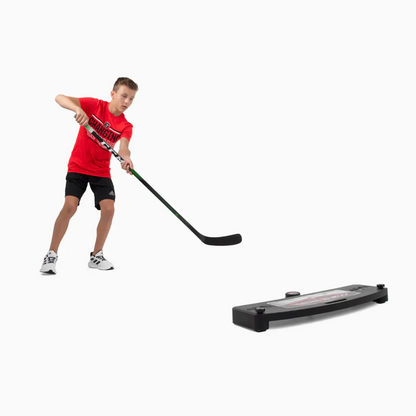 A photo of a child playing with the HockeyShot Extreme Passer 24" in colour black.
