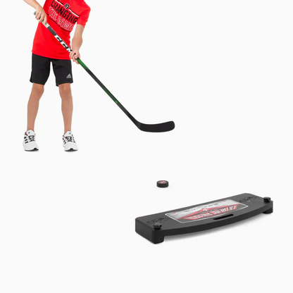 A photo of a child in a red shirt playing with the HockeyShot Extreme Passer 30" in colour black.