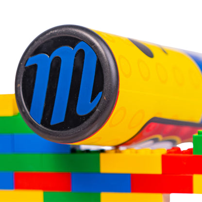 A photo of the Marucci Block Party 12.75" 2PC Loaded USSSA Slo-pitch Bat in colour blue, red and yellow. Multi colour Lego pieces in the background.