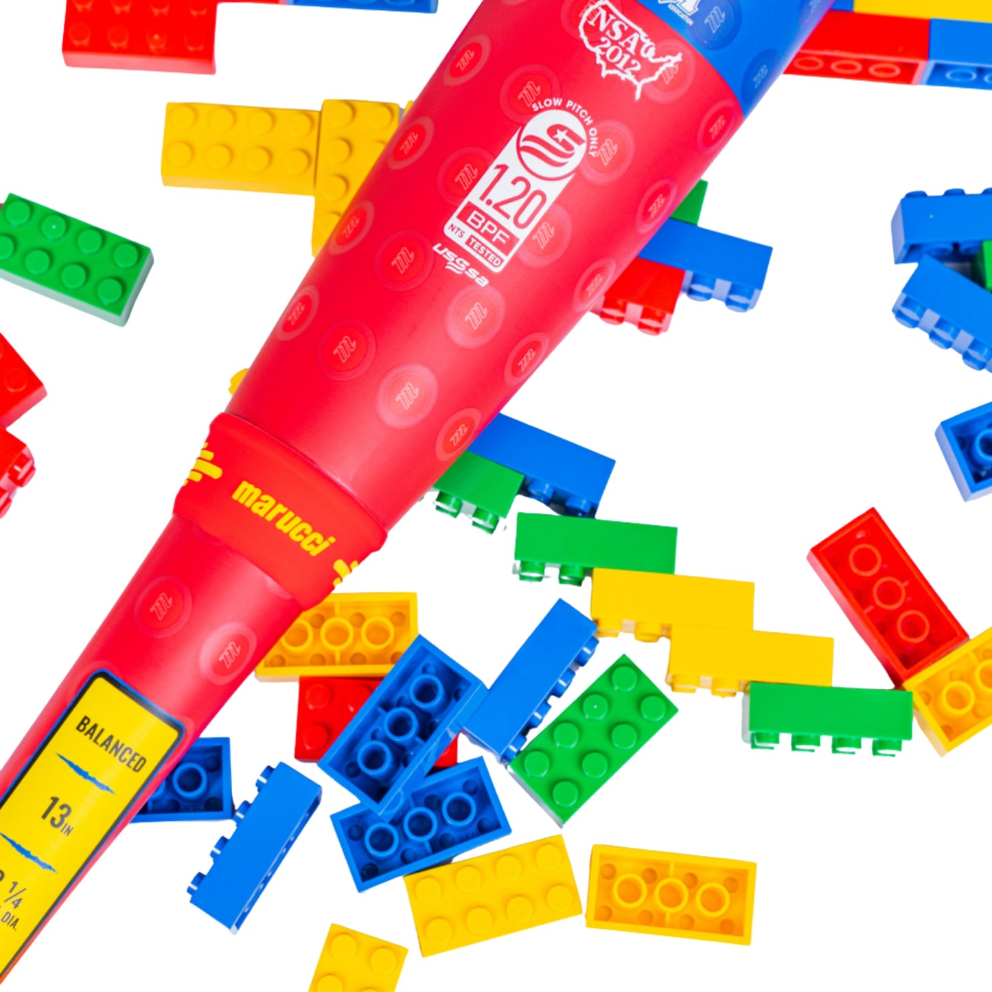 A photo of the Marucci Block Party 13" 2PC Balanced USSSA Slo-pitch Bat in colour yellow, blue, red. Multi coloured lego pieces in the background.