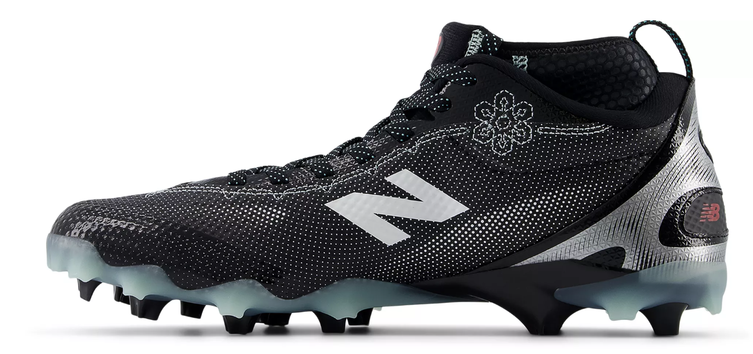 A photo of the New Balance Men's FreezeLX V5 Mid Lacrosse Cleats in colour black and white. Side view.