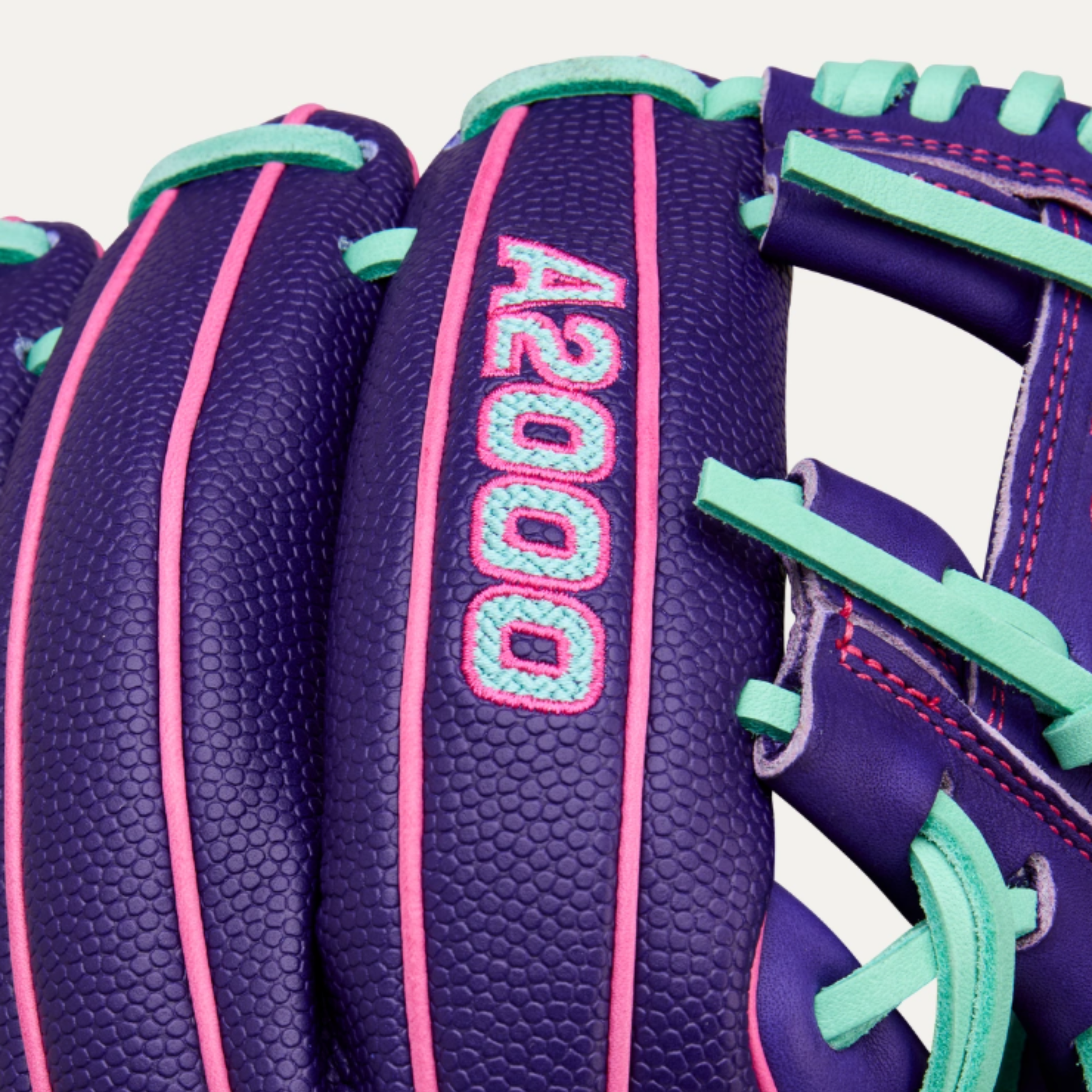 A photo of the Wilson Winter 2025 A2000® DP15SS 11.5" Infield Baseball Glove in colour purple, teal and pink.